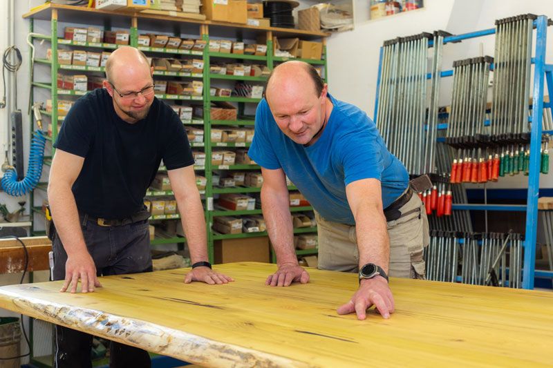 Zwei Arbeiter inspizieren Holzplatte